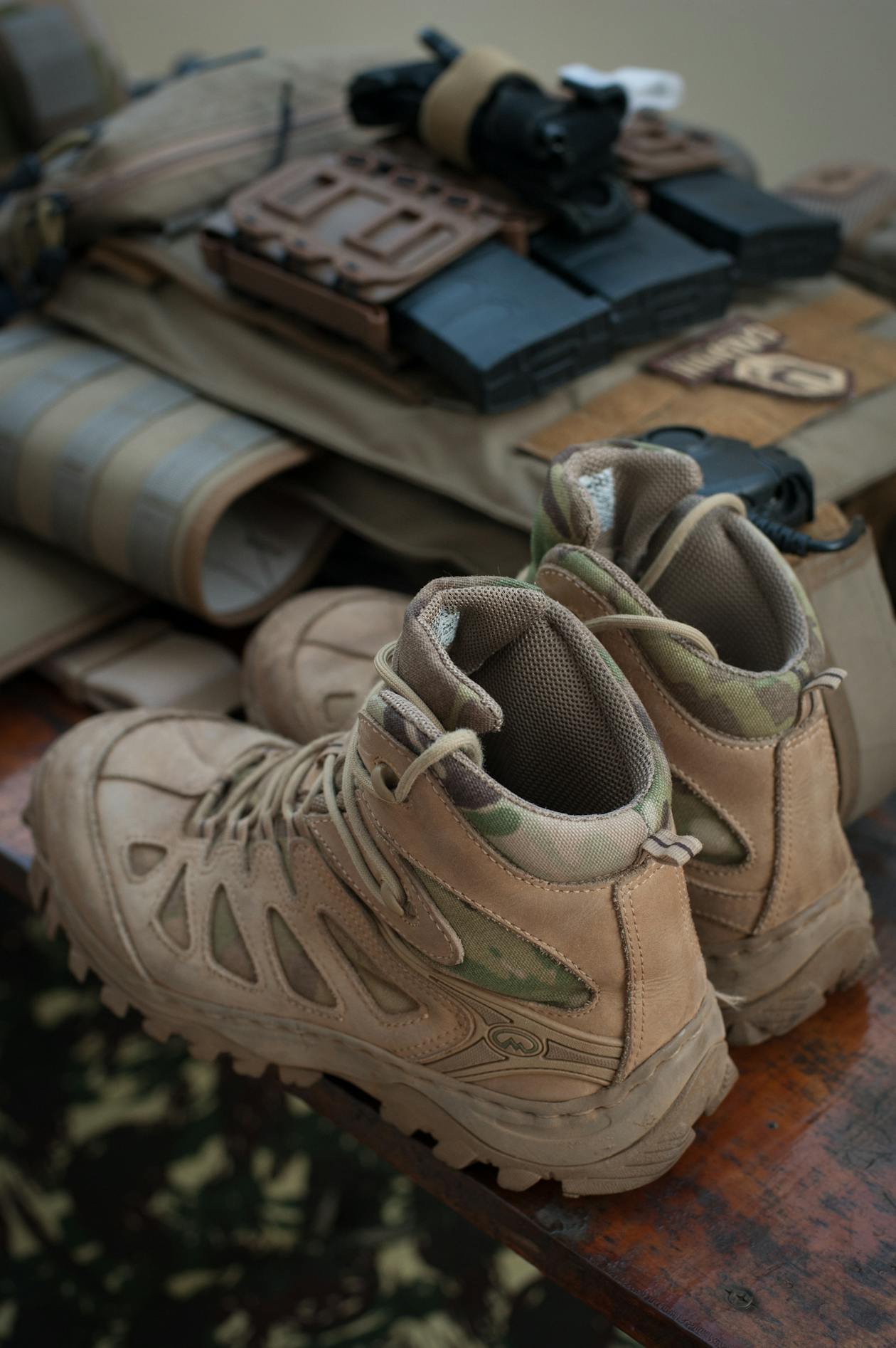 Hiking Boots and Outdoor Gear - Popular Outdoorsman Tactical hiking boots with outdoor gear on wooden surface — best hiking boots gear guide