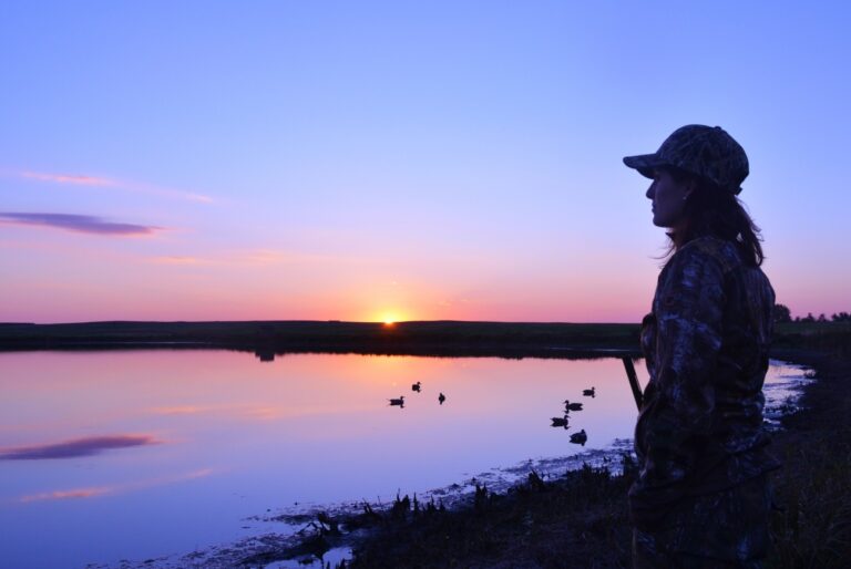 Hunter walks a wetland trail at a national wildlife refuge at sunrise, representing expanded national wildlife refuge hunting access in 2026