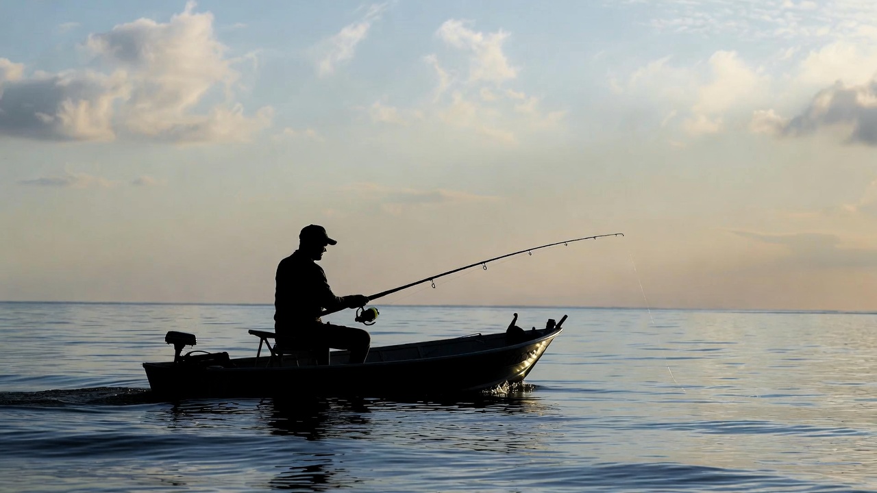 Man fishing on a boat sunset - Popular Outdoorsman Man fishing on a boat sunset