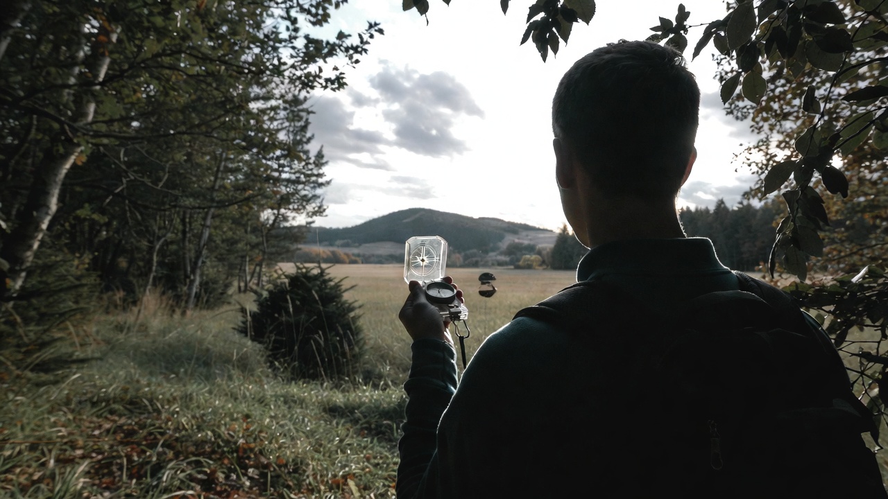 Man using a compass to find his way - Popular Outdoorsman Man using a compass to find his way