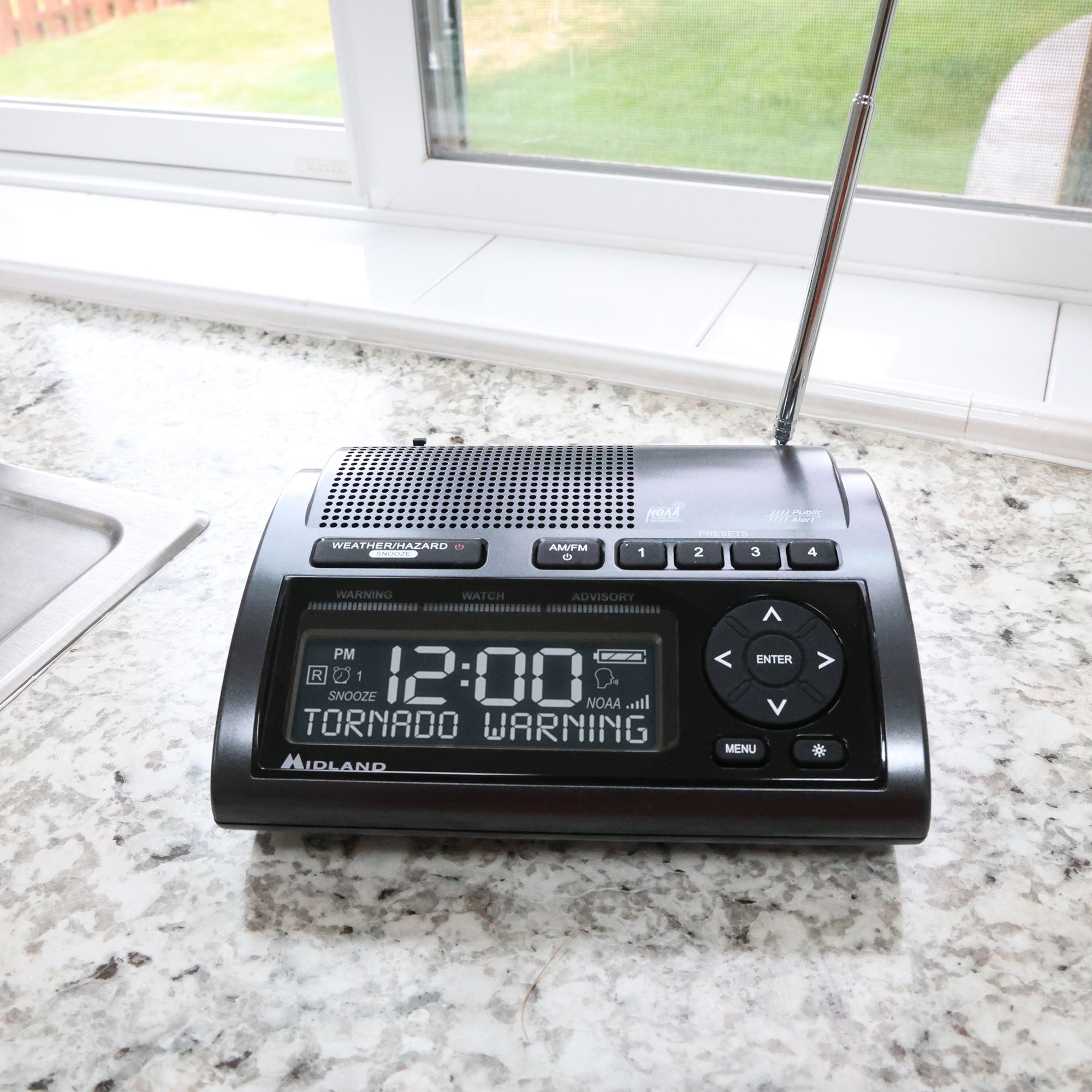WR400_Lifestyle_-03_2000X2000_4bff76e2-9b2d-416a-9e19-07ab5b3ec636 - Popular Outdoorsman Weather radio on a kitchen counter displaying a tornado warning, with a window in the background behind it.